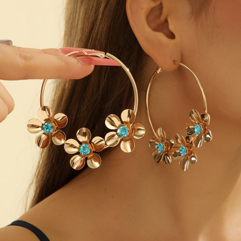 Women’s earrings with intricate flower design and pearl accents Nin Boutique