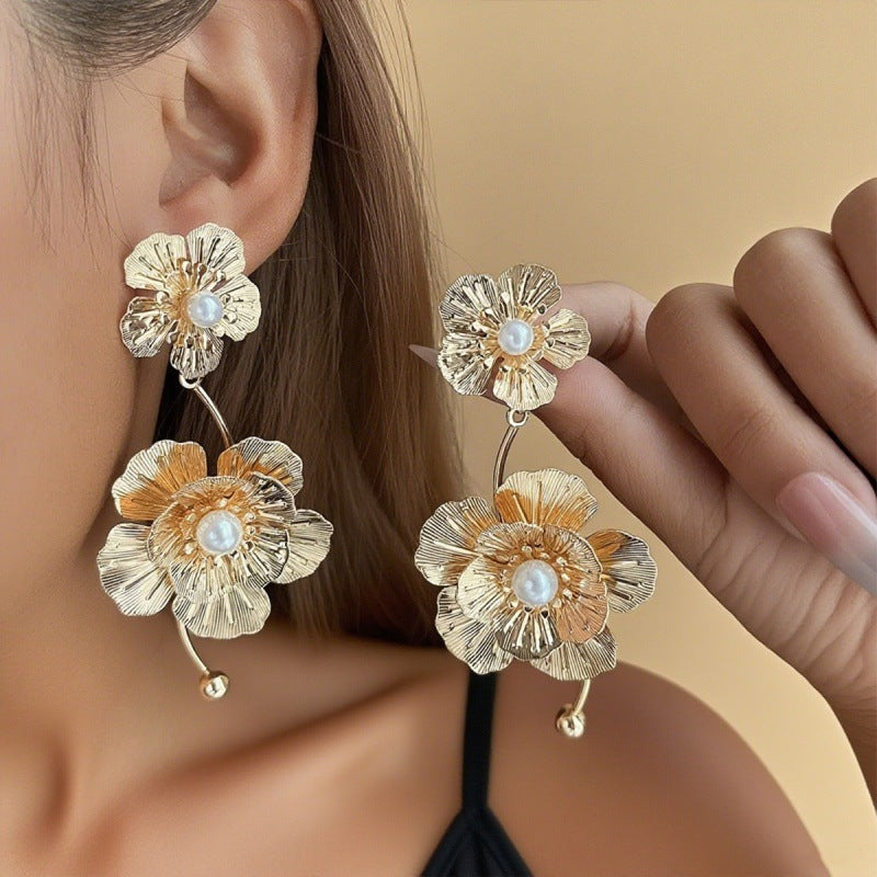 Women’s earrings with intricate flower design and pearl accents Nin Boutique