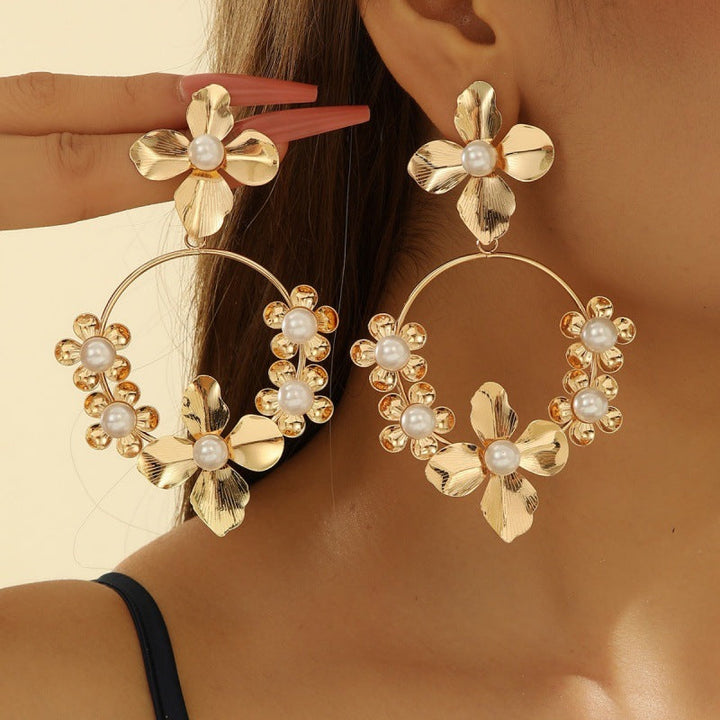 Women’s earrings with intricate flower design and pearl accents Nin Boutique