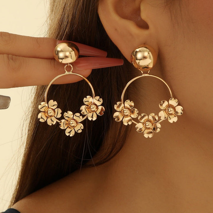 Women’s earrings with intricate flower design and pearl accents Nin Boutique