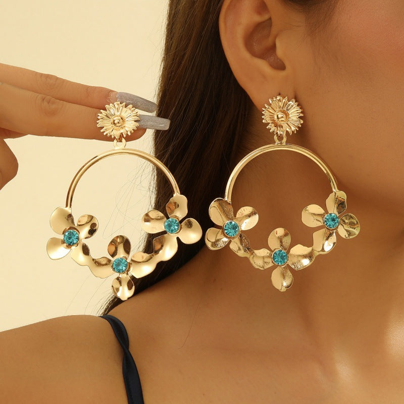 Women’s earrings with intricate flower design and pearl accents Nin Boutique