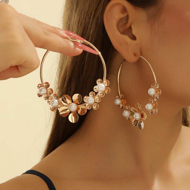 Women’s earrings with intricate flower design and pearl accents Nin Boutique